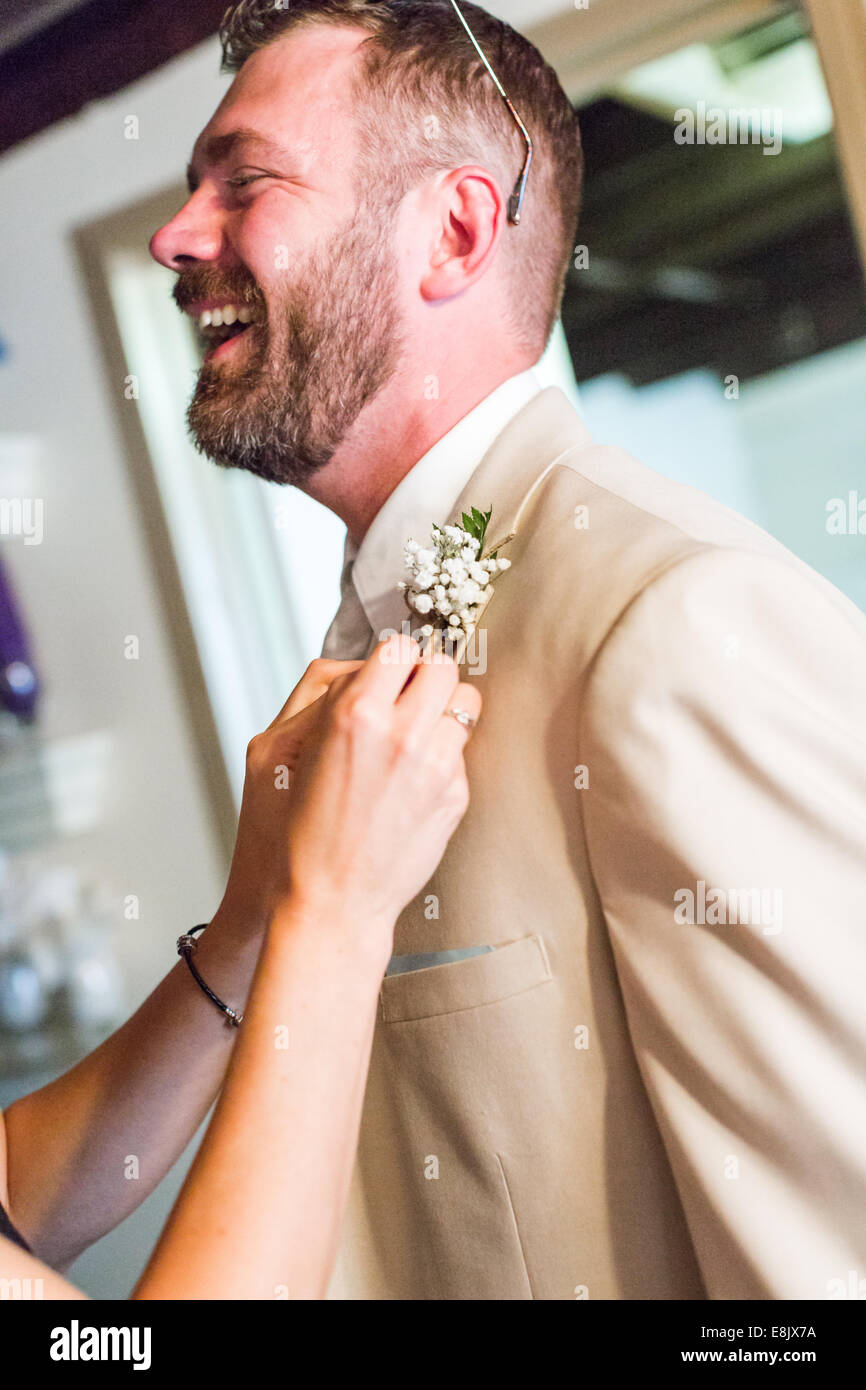 Boutonniere pin up to grooms suit right before wedding ceremony Stock Photo  - Alamy