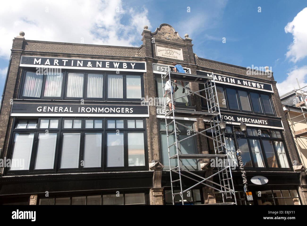 Painters working on scaffolding painting the Martin and Newby