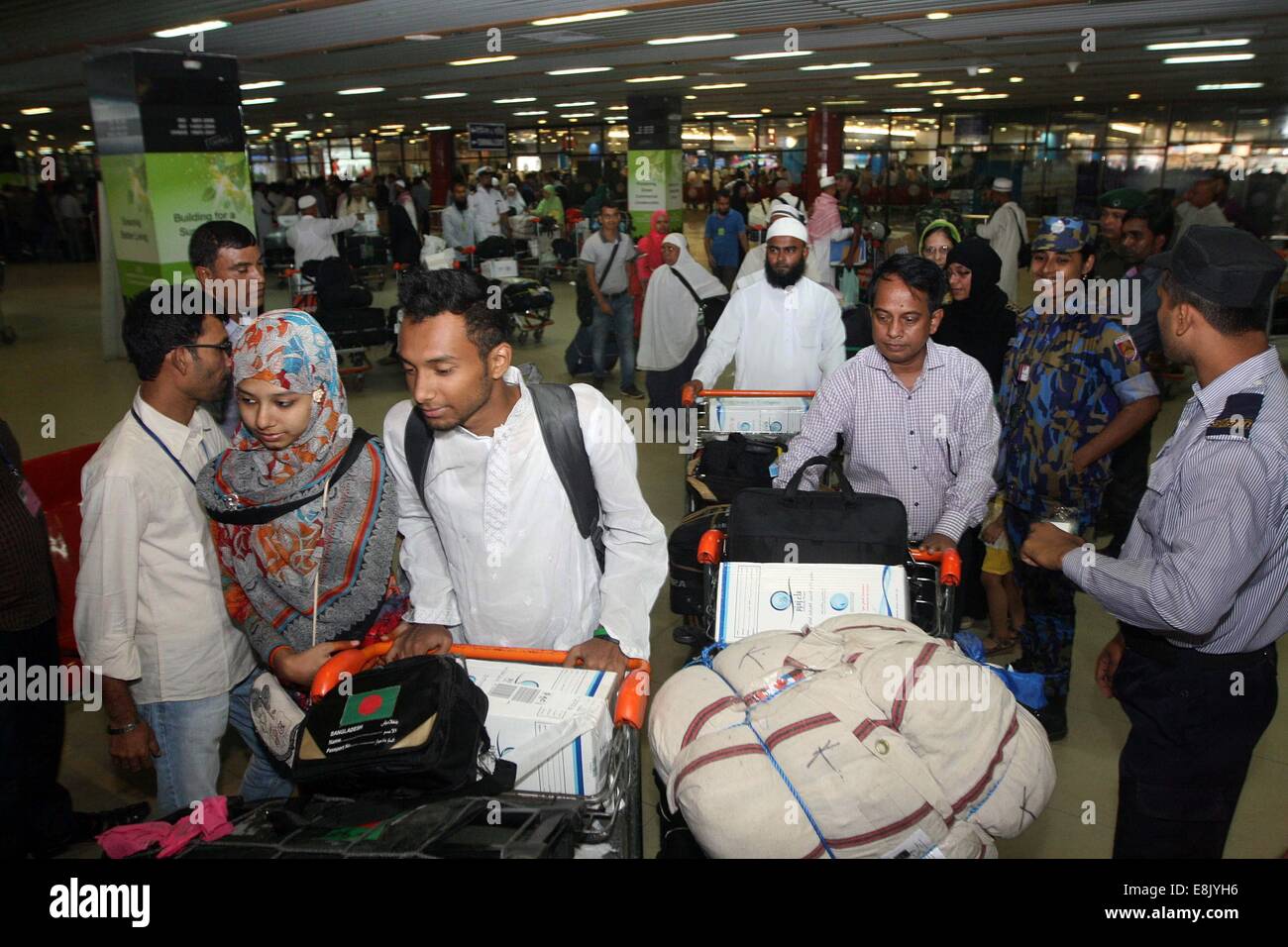 Dhaka, Bangladesh. 9th October, 2014. Bangladeshi hajj pilgrims arrive by a flight of Biman Bangladesh Airlines at Hazrat Shahjalal International Airport. This year 99,000 Bangladeshis perform Hajj. Stock Photo