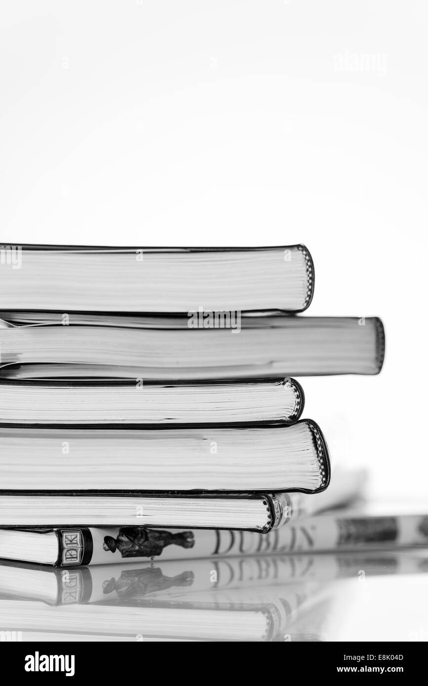 view of a stack of books, pile of 6 books, white background, lines of colour, mainly white with strips of colour, purple, DK Stock Photo