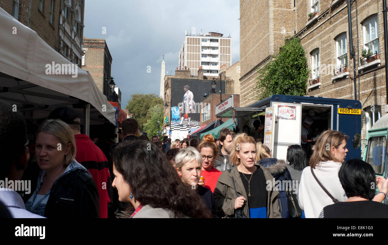 London, UK. 9th October, 2014.   In autumn sunshine office workers flood into Whitecross St. market near the Barbican at midday to buy lunch at ethnic street food stalls and vans.  Despite a rainy outlook forecast the day continues to be extremely windy but dry into the afternoon. Credit:  Kathy deWitt/Alamy Live News Stock Photo