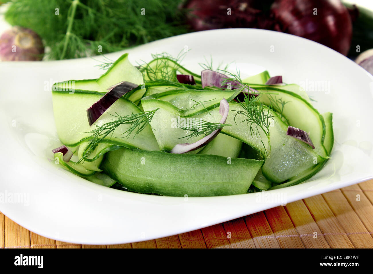 a bowl of cucumber salad with dill and red onions Stock Photo