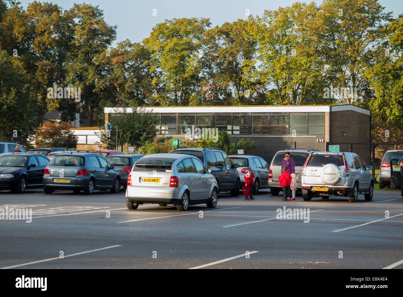 School car park during term time / cars parking in the morning drop off at a primary and secondary school. UK. Stock Photo