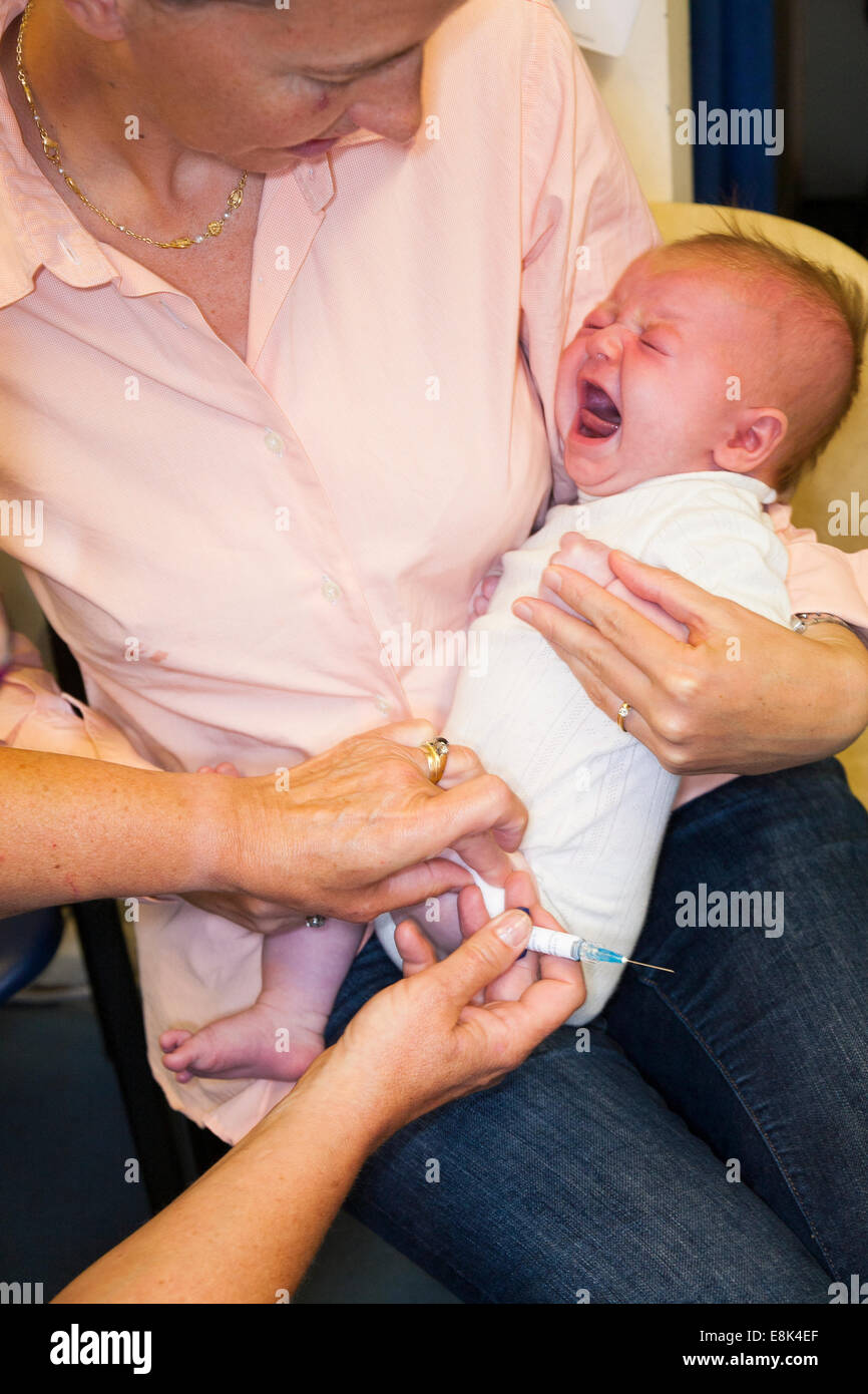 DTap IPV Hib & PCV immunisation / inoculation / jab / from a syringe into 8 / 9  eight / nine week old baby's thigh / leg Stock Photo