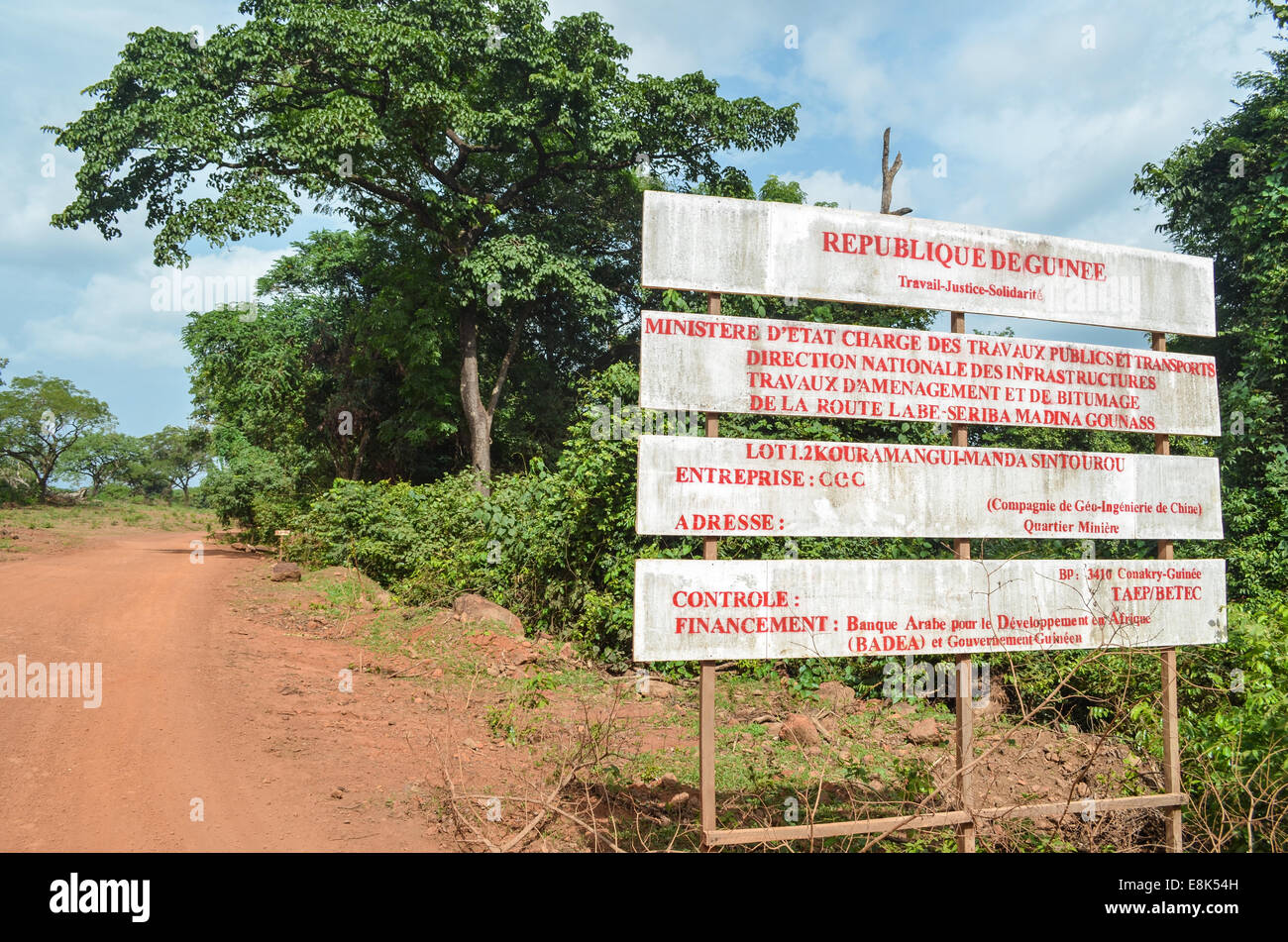 Road sign about the construction of a new road in the Republic of Guinea Stock Photo