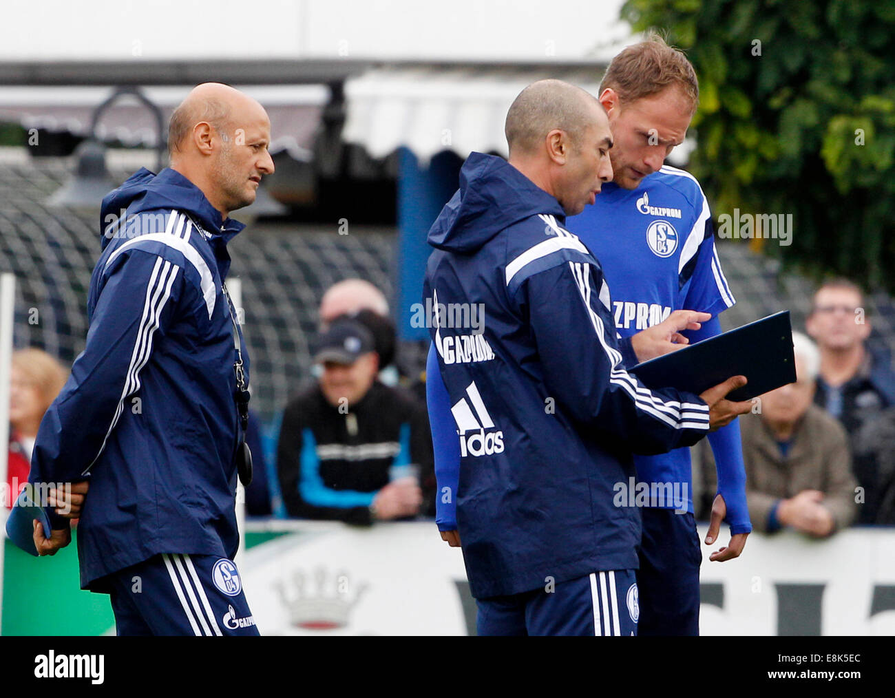 Geselnkirchen, Germany. 9th Oct, 2014. The new headcoach of German Bundesliga soccer club Schalke 04, Roberto di Matteo, talks to Benedikt Hoewedes (R) as he leads his first training session in Geselnkirchen, Germany, 09 October 2014. New assistant coach Attilio Lombardo stands next to them. Matteo takes over from Jens Keller. Photo: Roland Weihrauch/dpa/Alamy Live News Stock Photo