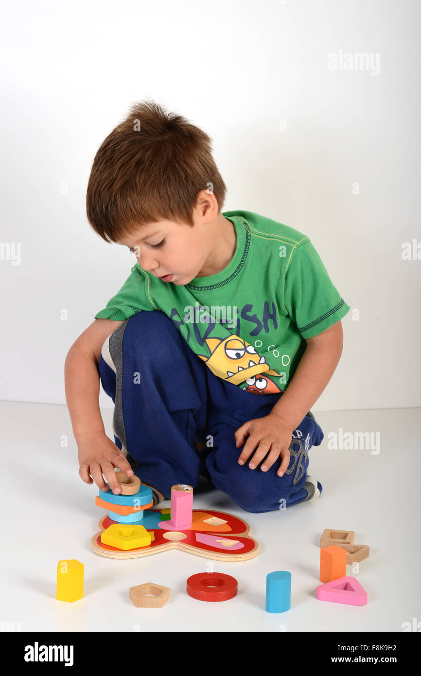 Child playing with childrens educational jigsaw jigsaws toy toys uk Stock Photo