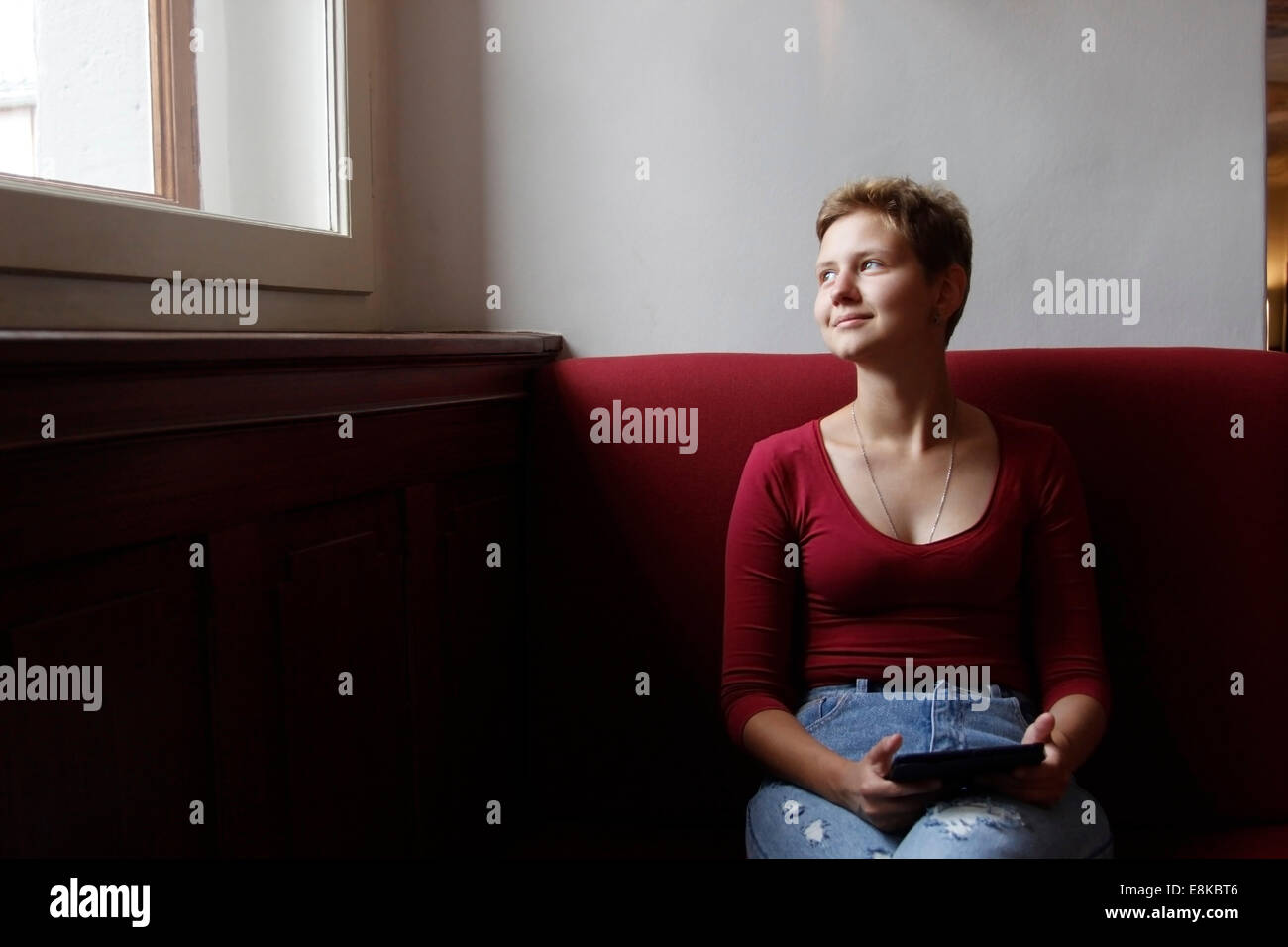 Teenage girl sitting on sofa with tablet computer Stock Photo - Alamy