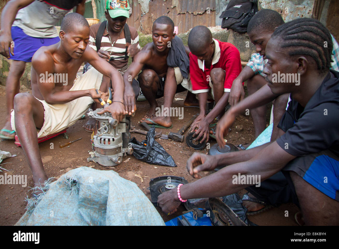 Men disassembling electric motor to sell scrap metal, Kroo Bay, Freetown, Sierra Leone. Photo © Nile Sprague Stock Photo