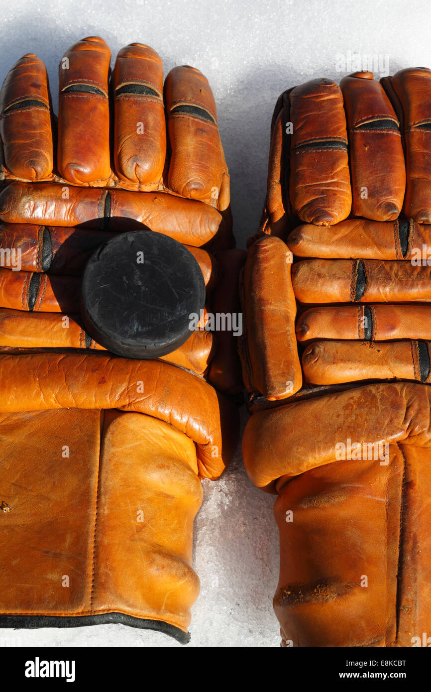 Vintage ice hockey gloves and puck lying on ice Stock Photo Alamy