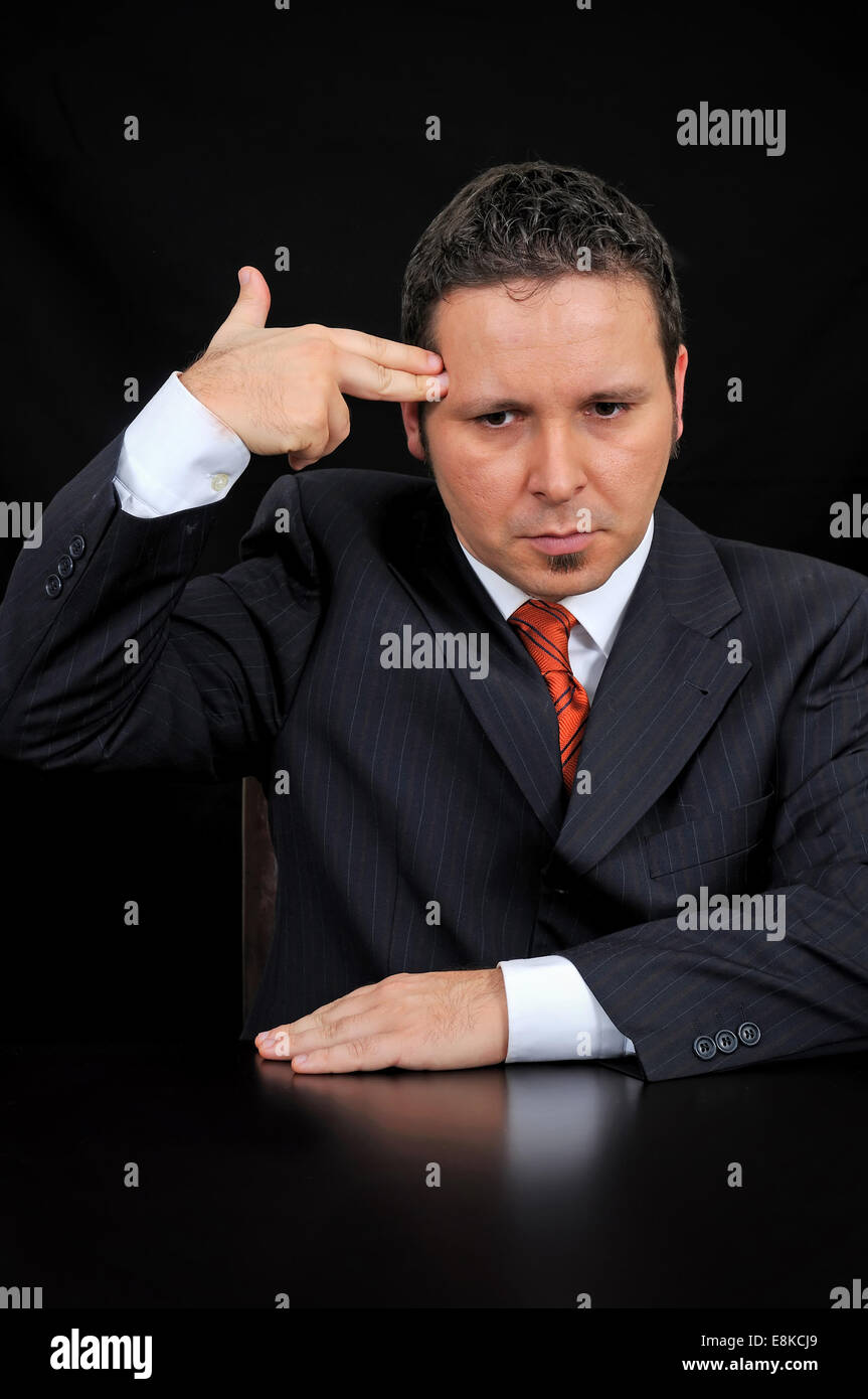 Young Businessman holding hand to his head, mimicking a gun. Stock Photo