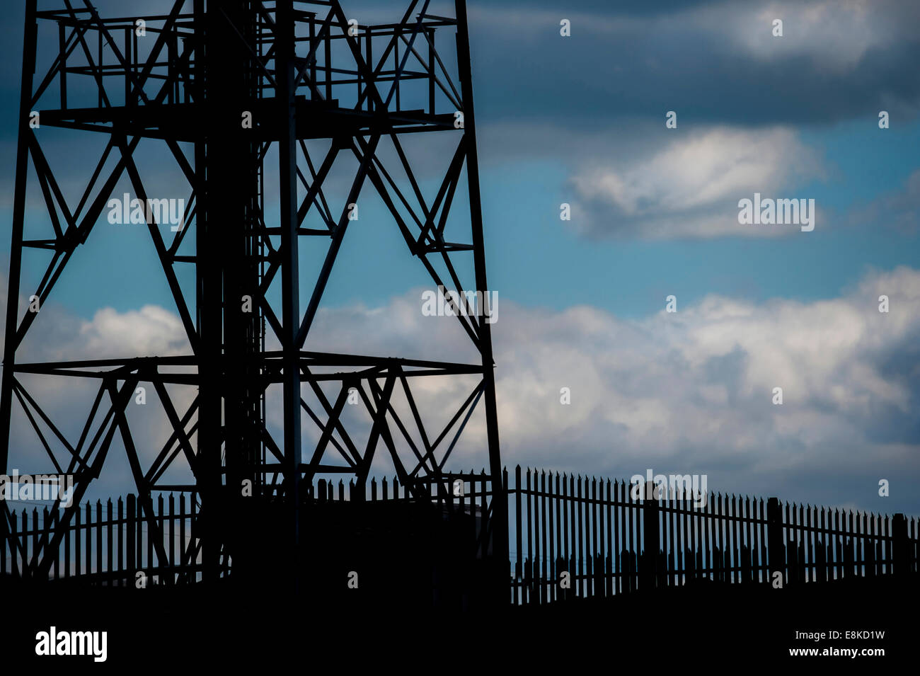 Silhouette of mobile phone mast and fencing. Stock Photo