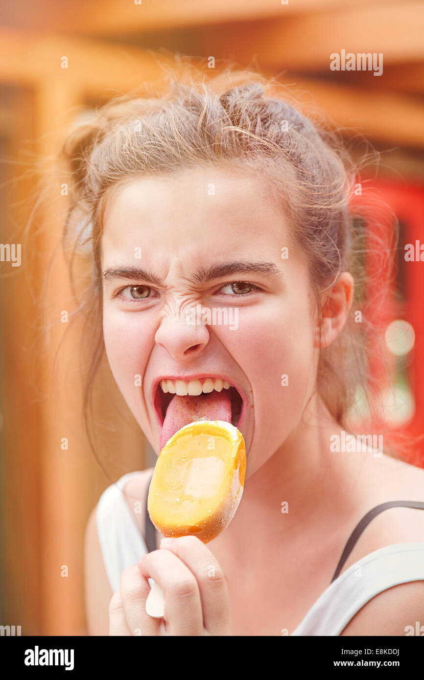 portrait of an eager teenage girl eating popsicle Stock Photo