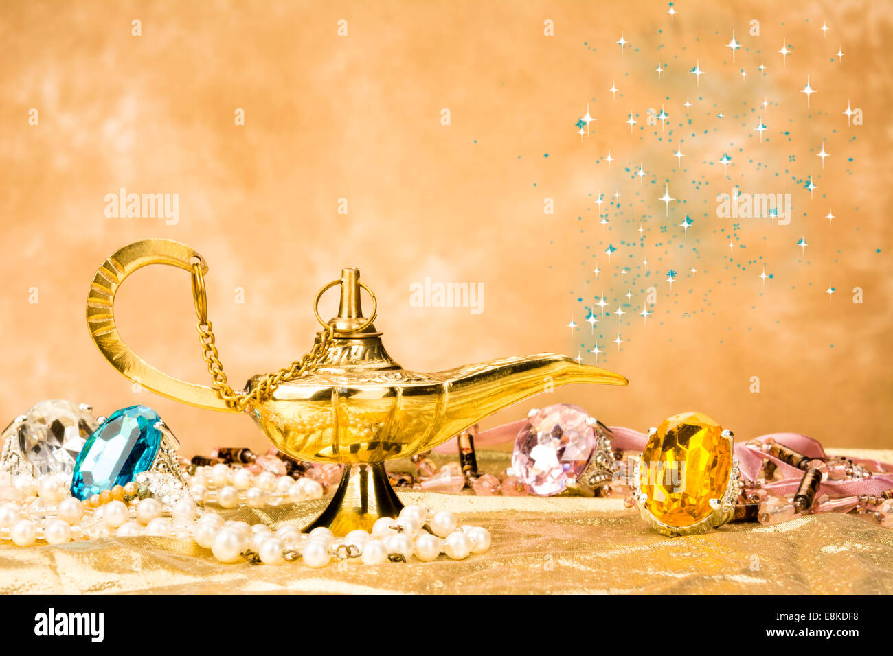 The formation of a magical deity from a gold, magic lamp surrounded by a wealth of jewelry and fantasy. Stock Photo