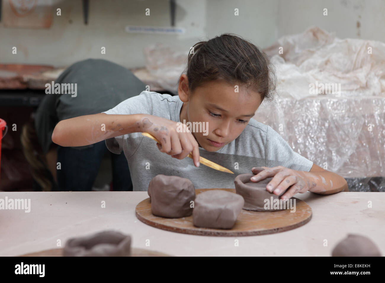Young Girl Takes Part In A Pottery Class Learning How To Decorate