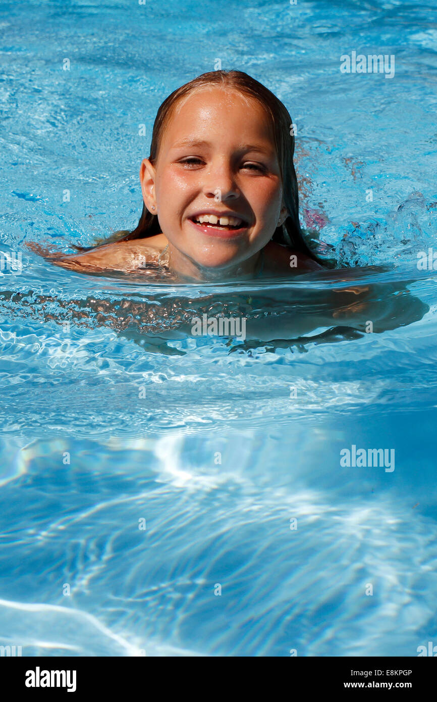 A 10-year old girl swimming in a swimming pool. Stock Photo