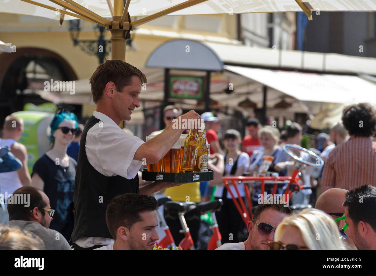 A barman holding a tray with glasses filled with beer, Prague, Czech