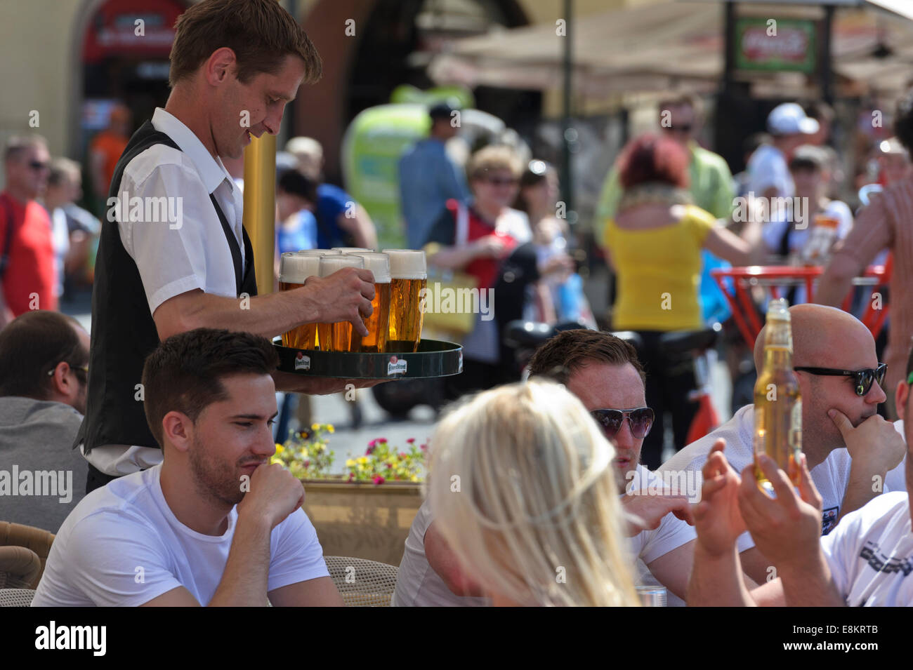 A barman holding a tray with glasses filled with beer, Prague, Czech