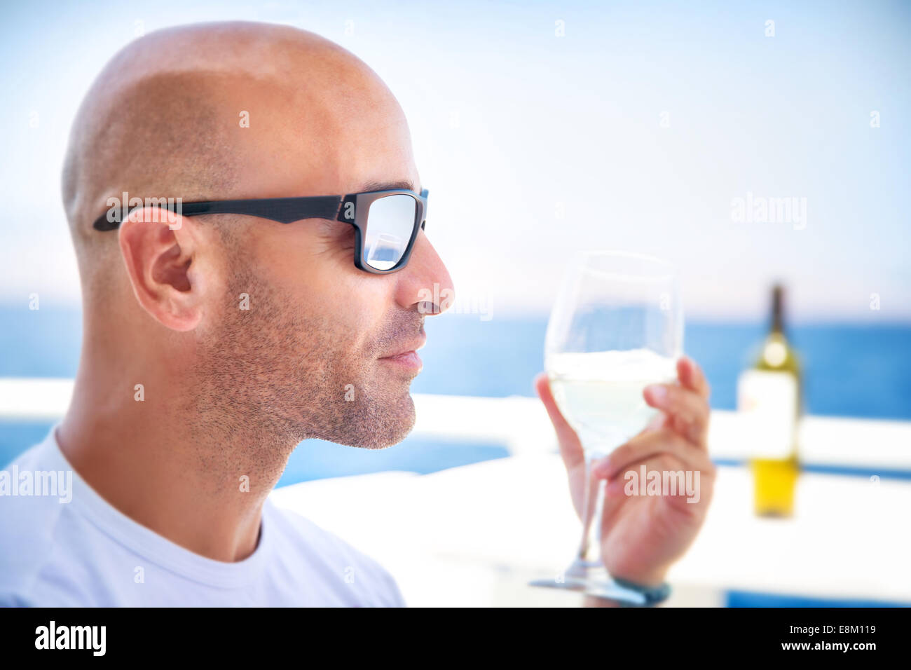 Closeup portrait of handsome man drinking wine in outdoors restaurant ...