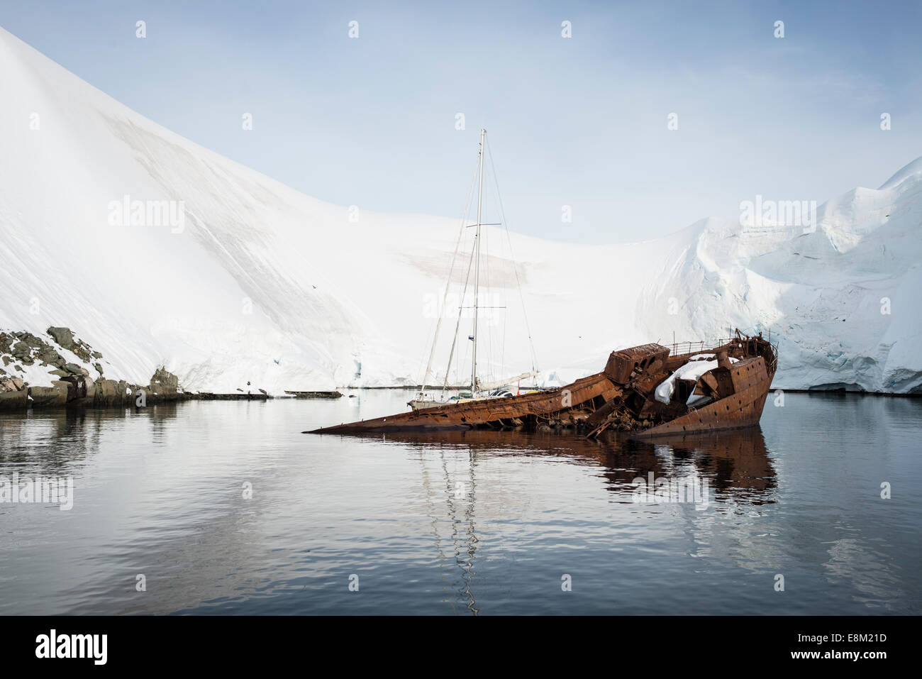 Sailing boat tied up to a shipwreck, Antarctica Stock Photo