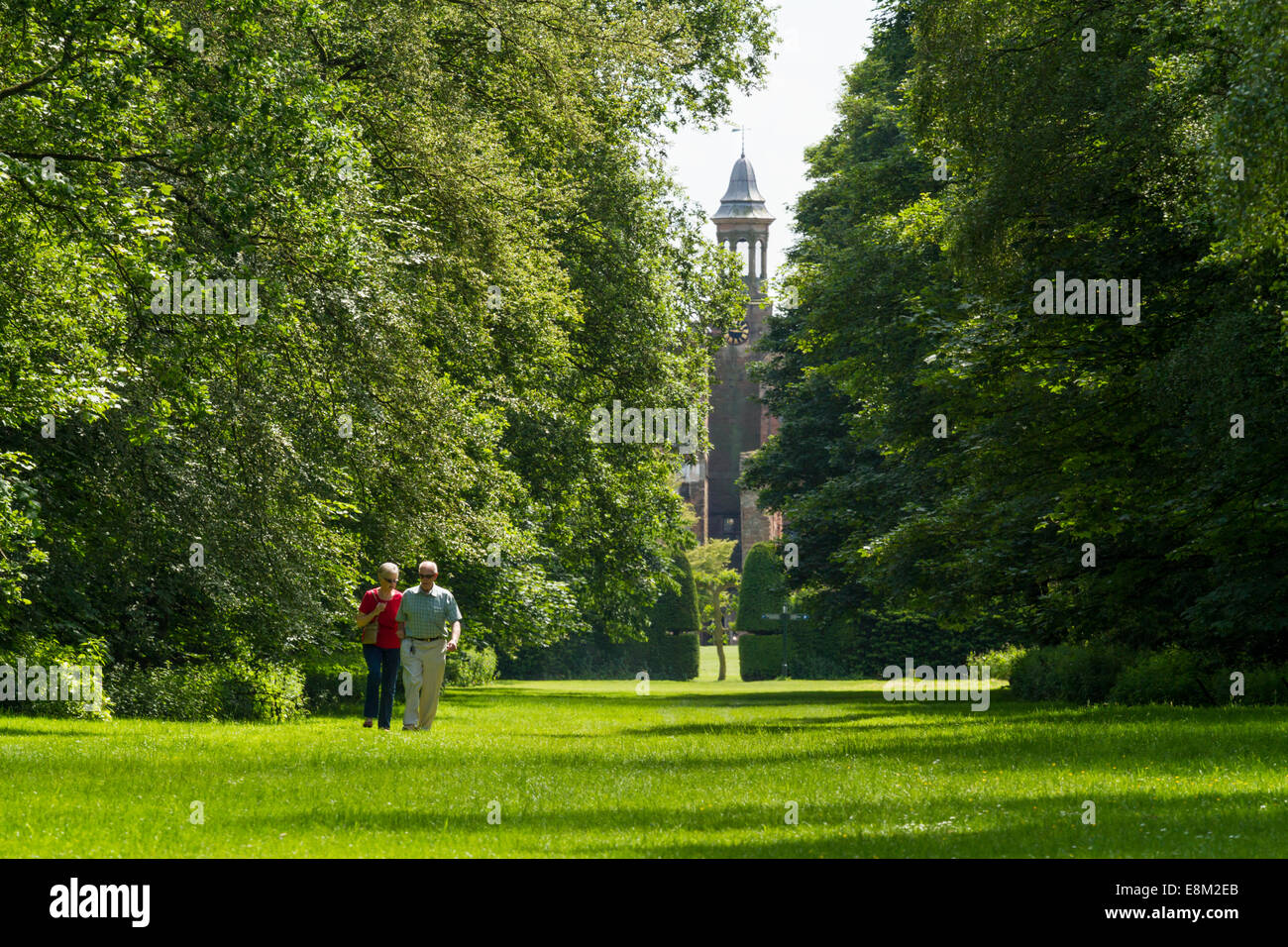 People walking along Broad Ride, a long tree lined avenue of grass at Rufford Abbey Country Park, Nottinghamshire, England, UK Stock Photo