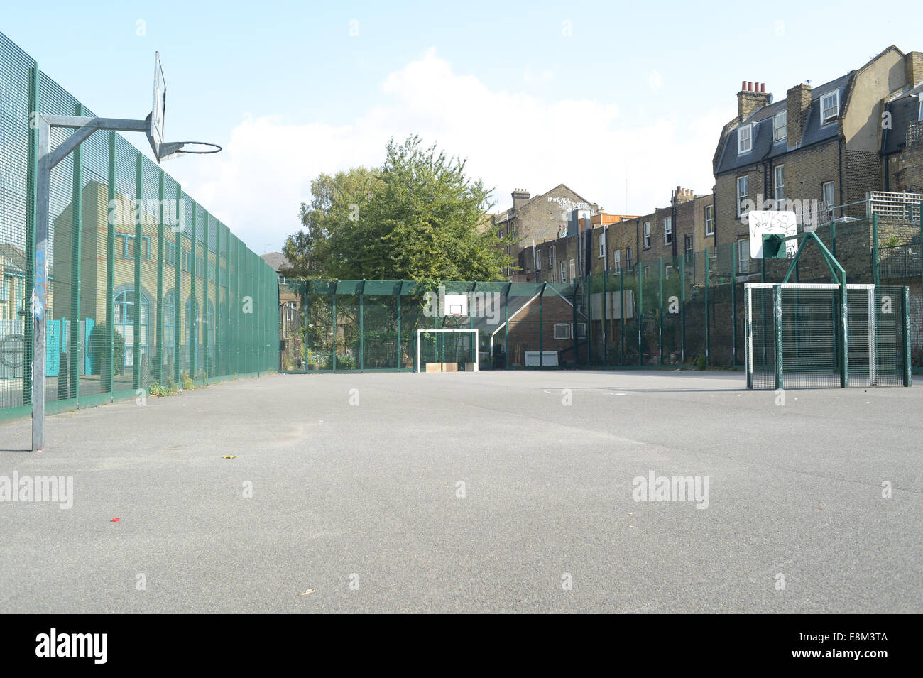 view from the street of East London of a basketball  playground near a council estate Stock Photo