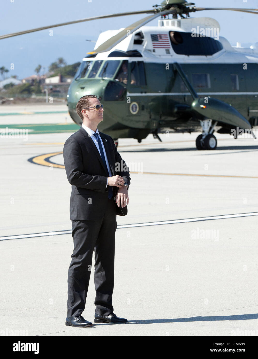 Los Angeles, California, USA. 9th Oct, 2014. A US Secret Service Agent stands by on the tarmac at LAX alongside what will be Marine One as he waits for the imminent arrival of Air Force One carrying President Barack Obama on Thursday October 9, 2014. Credit:  David Bro/ZUMA Wire/Alamy Live News Stock Photo