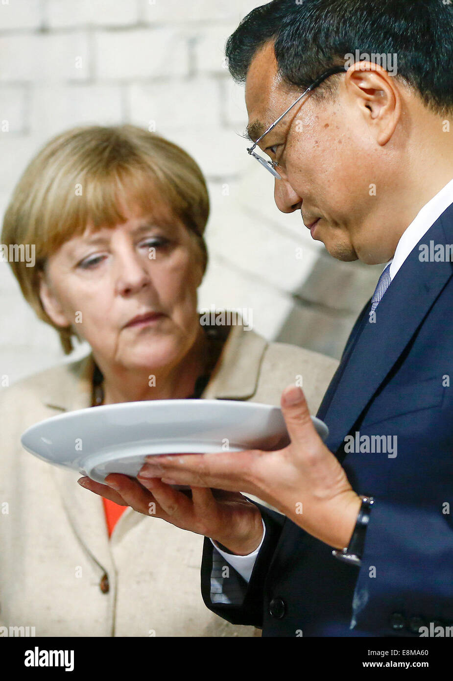 Berlin, Germany. 10th October, 2014. Germany's Chancellor Angela Merkel (L) and China's Premier Li Keqiang visit the Royal Porcelain Factory KPM (Koenigliche Porzellan-Manufaktur) in Berlin October 10, 2014. Credit:  dpa picture alliance/Alamy Live News Stock Photo
