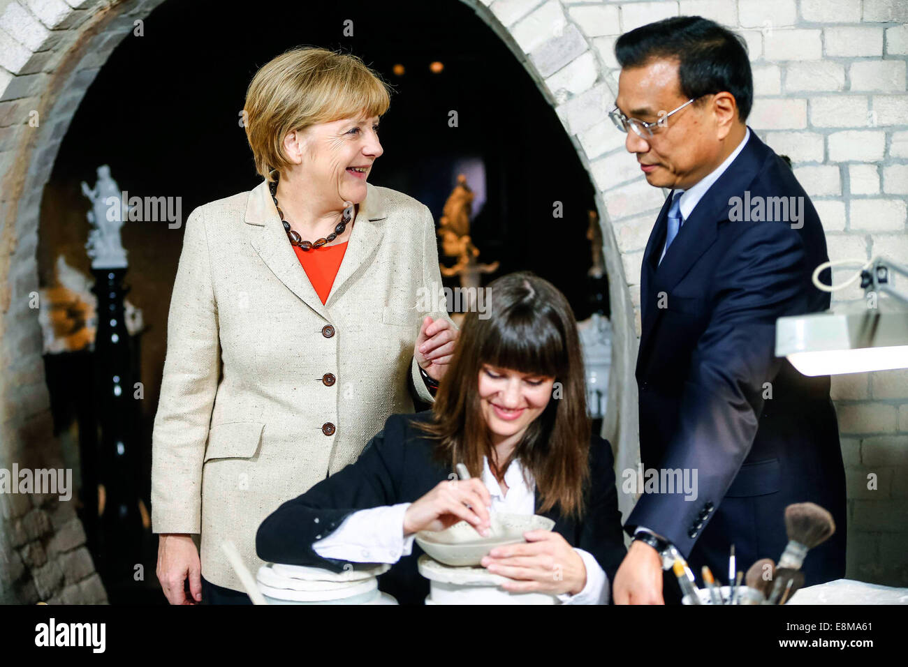 Berlin, Germany. 10th October, 2014. Germany's Chancellor Angela Merkel (L) and China's Premier Li Keqiang (R) visit the Royal Porcelain Factory KPM (Koenigliche Porzellan-Manufaktur) in Berlin October 10, 2014. Credit:  dpa picture alliance/Alamy Live News Stock Photo