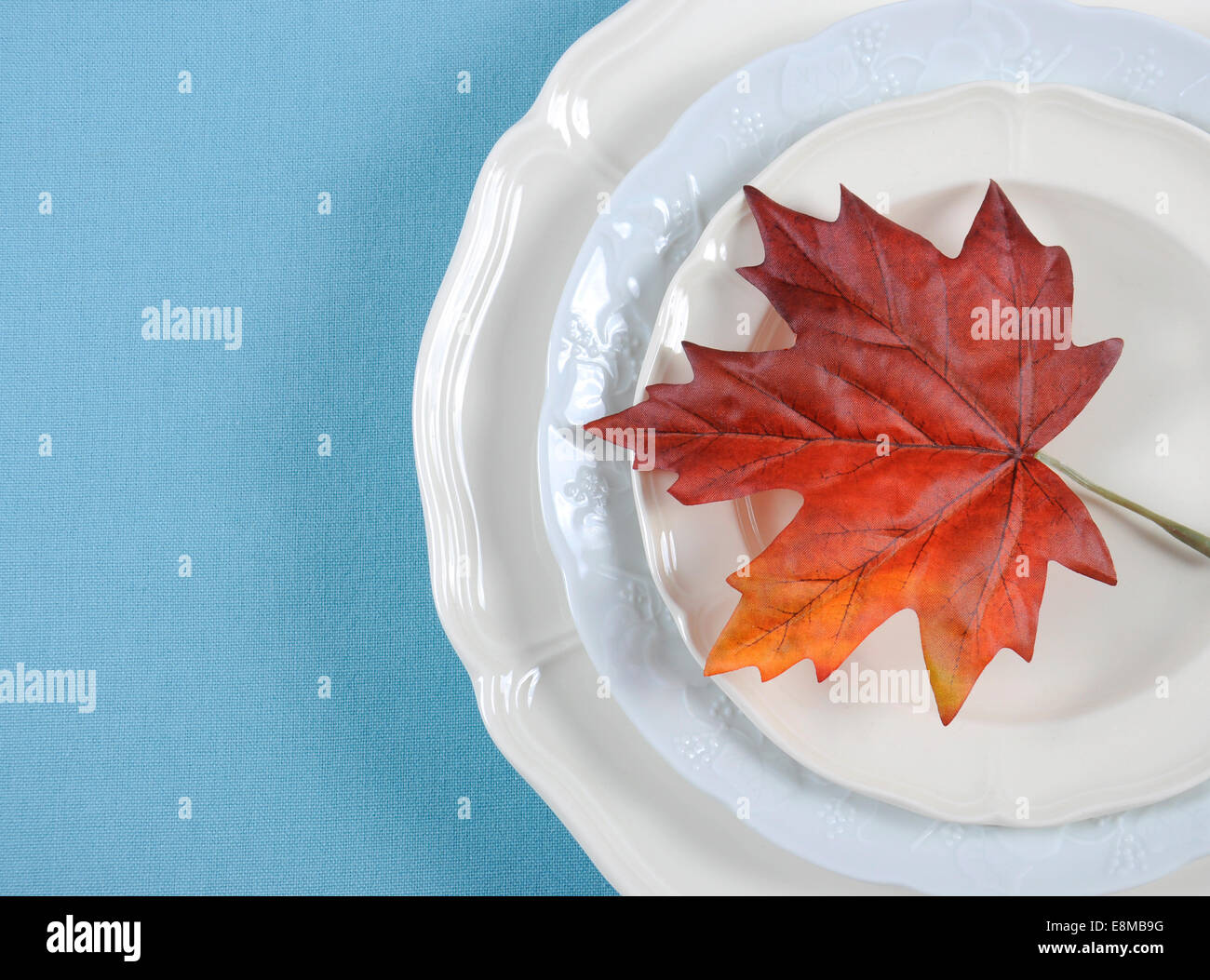 Happy Thanksgiving dining table elegant place setting in pale aqua blue and white theme with autumn leaf, with copy space. Stock Photo