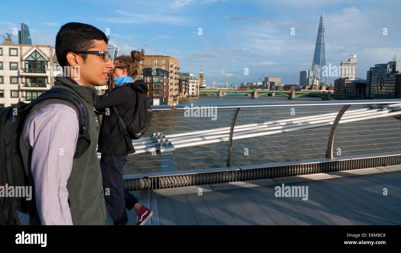 Millennium Bridge, London UK. 10th October 2014.  People late Friday afternoon enjoying the autumn sunshine as they cross the Millennium  or 'wobbly' Bridge which joins the North and South banks of the River Thames.  The forecast for London tomorrow is for a mixture of scattered thundery showers and sunny spells in the afternoon. Credit:  Kathy deWitt/Alamy Live News Stock Photo