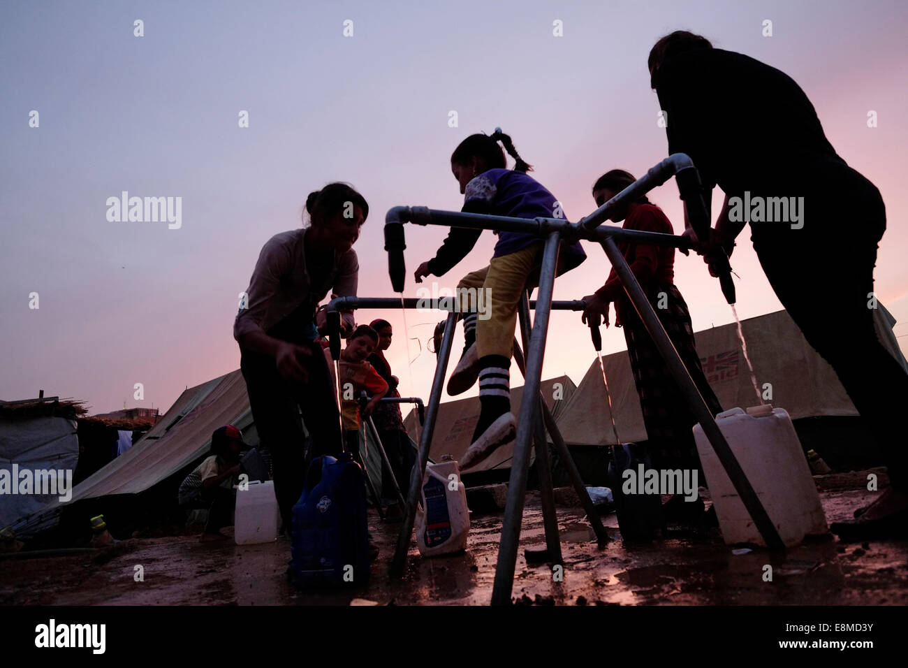 Yazidi Women Filling Drinking Water In Plastic Jerrycans At A Refugee