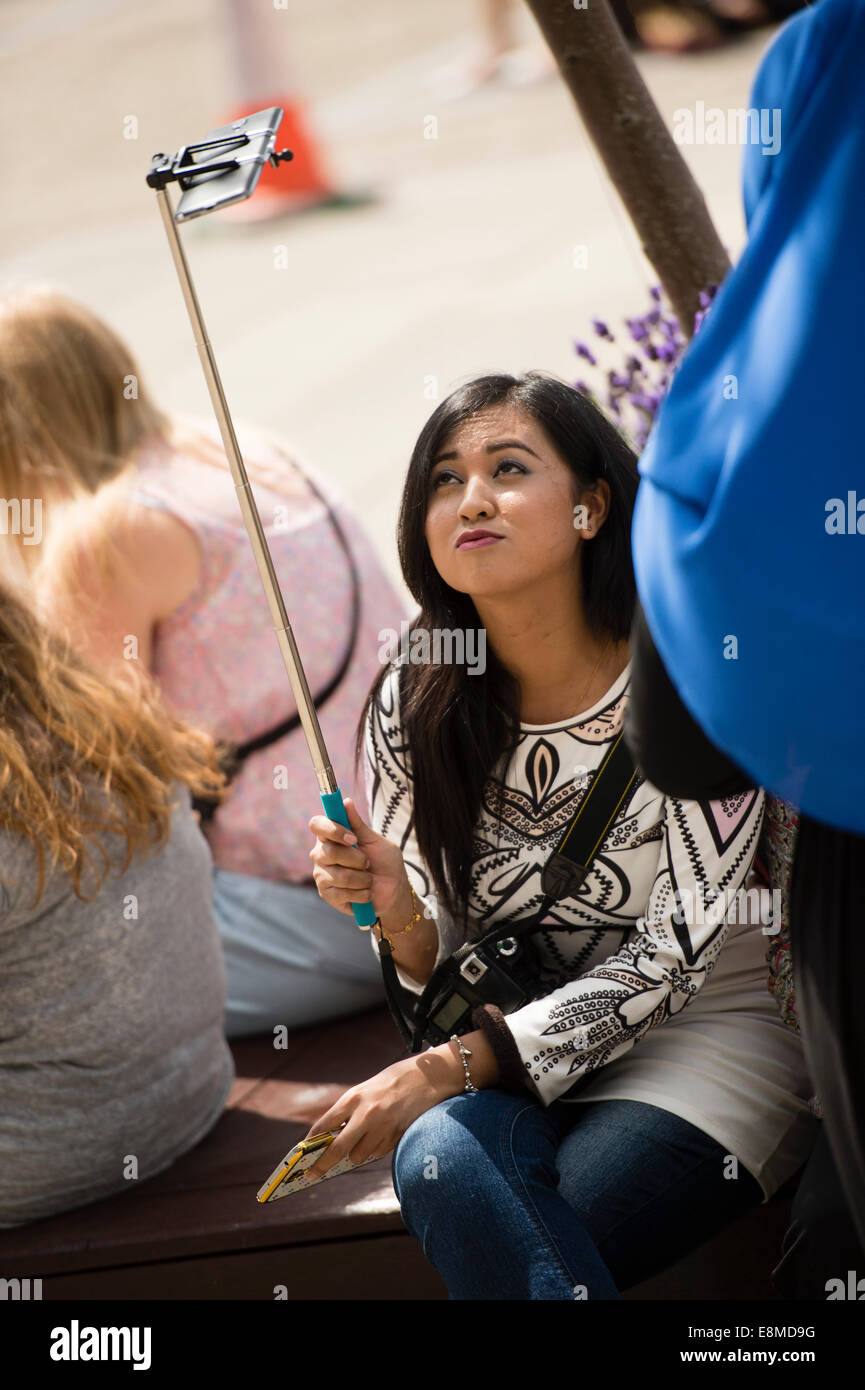 A young woman girl taking a selfie with her iPhone smart phone mobile ...