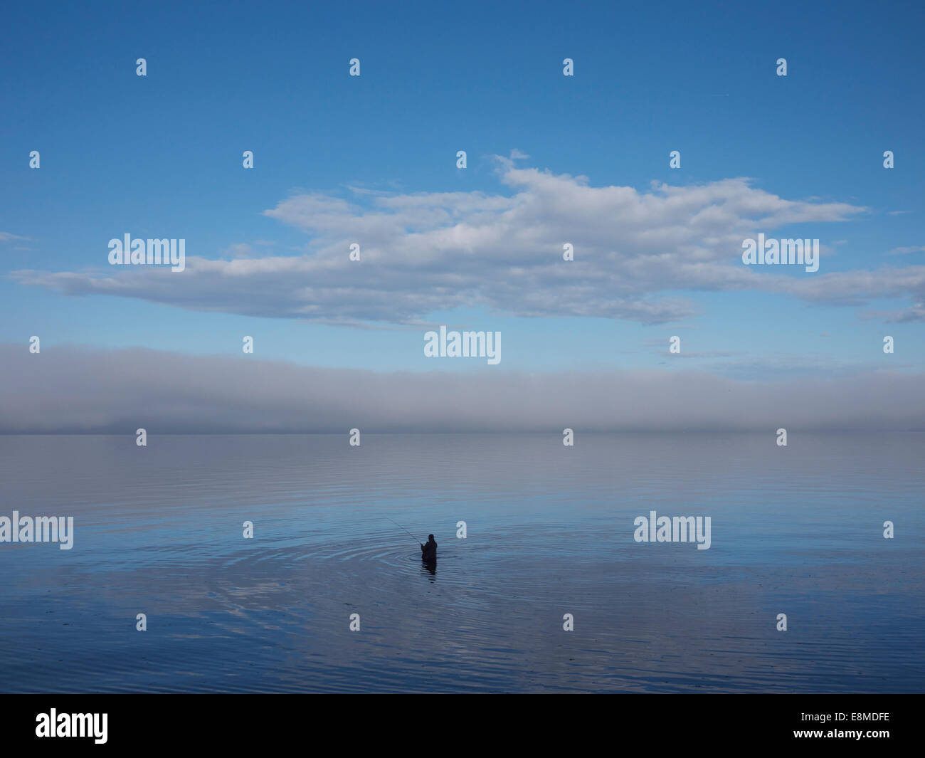 lone fisherman in Pacific ocean off the coast of Vancouver Island near Comox British Columbia Canada Stock Photo