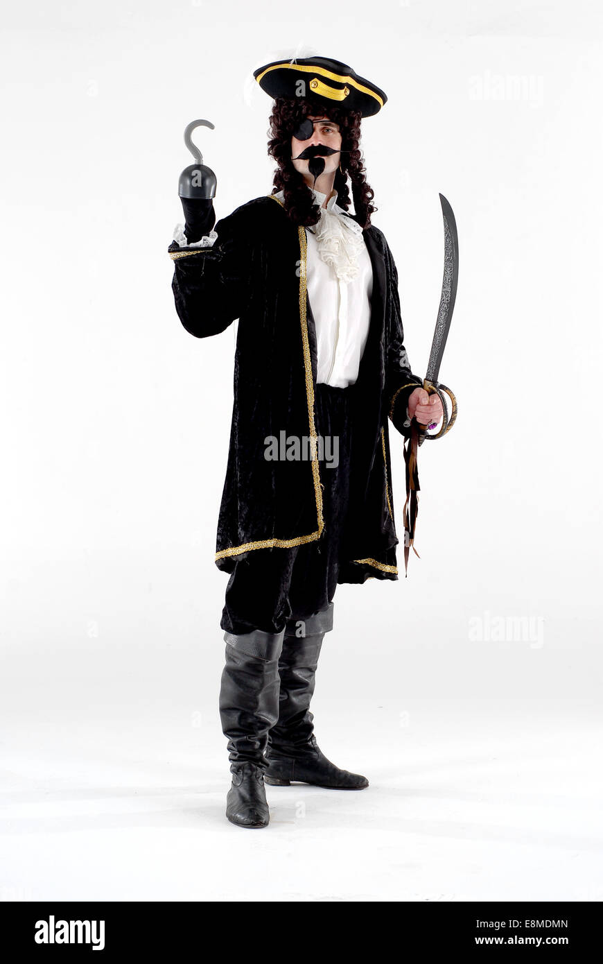 Man dressed in fancy dress comedy costume as captain hook the pirate character from peter pan against a white background, Stock Photo