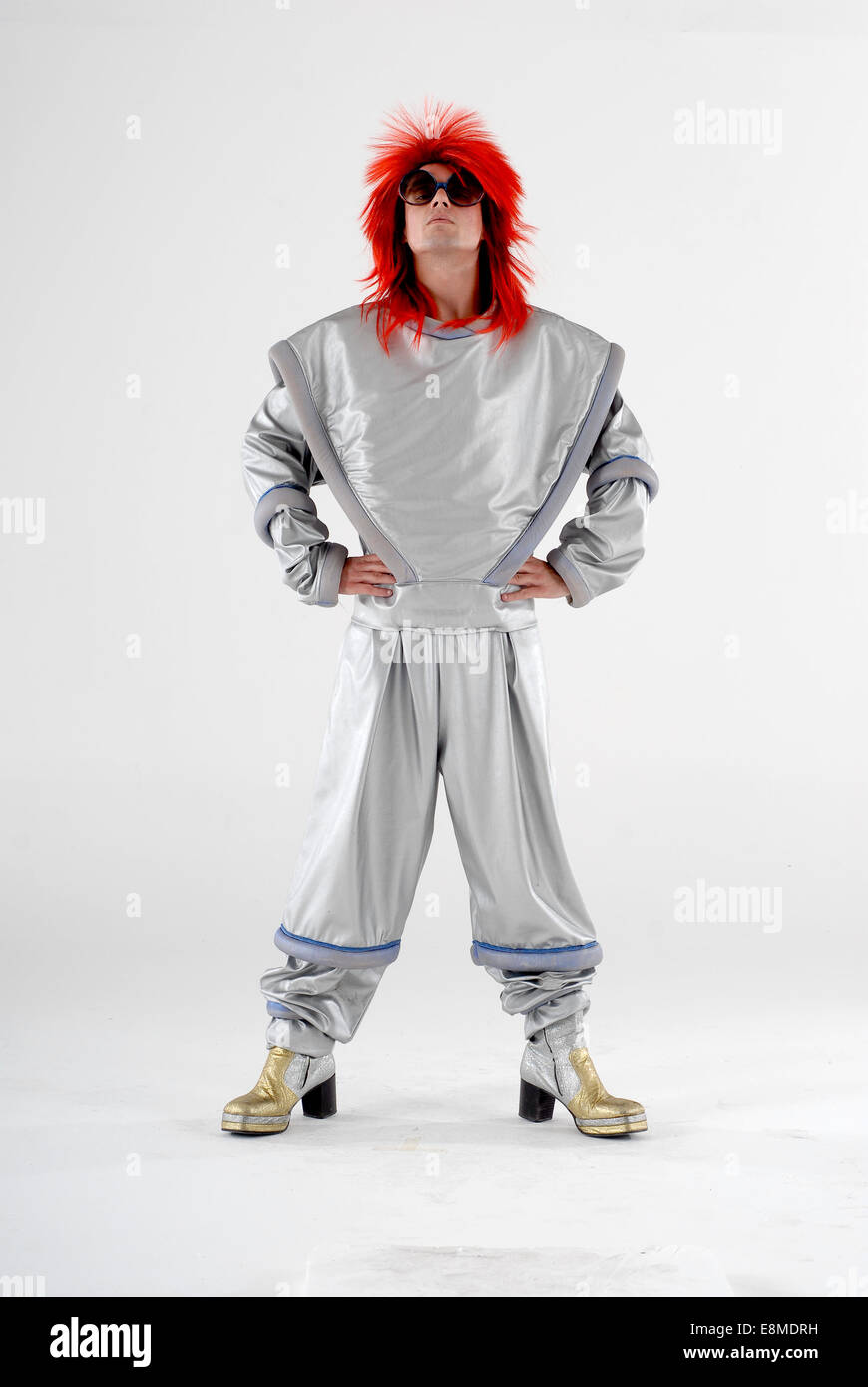 man in fancy dress, comedy costume as a ziggy stardust david bowie, space  age character, with shiny silver suit, wig & platforms Stock Photo - Alamy