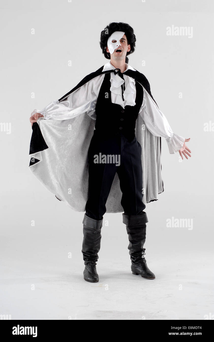 man in fancy dress comedy costume as the phantom of the opera from the musical, with mask, cape and full outfit Stock Photo
