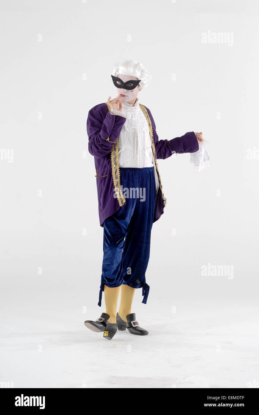 man dressed in fancy dress comedy costume as a historical royal court foppish figure with make up  and mask and full outfit Stock Photo
