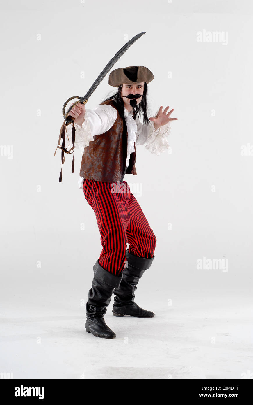 man in fancy dress comedy costume as a pirate with hat, goatee beard, sword, boots and full outfit Stock Photo