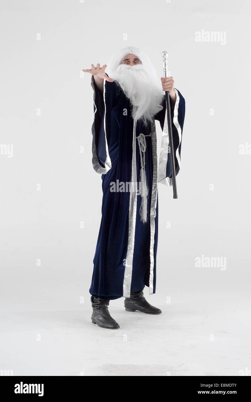 man in fancy dress comedy costume as a moses / god like figure or a wizard with white long hair, beard and blue gown Stock Photo