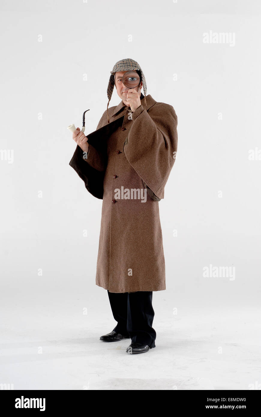man dressed in victorian sherlock holmes outfit from the popular books and TV show, with deerstalker hat, cloak, pipe, glass Stock Photo