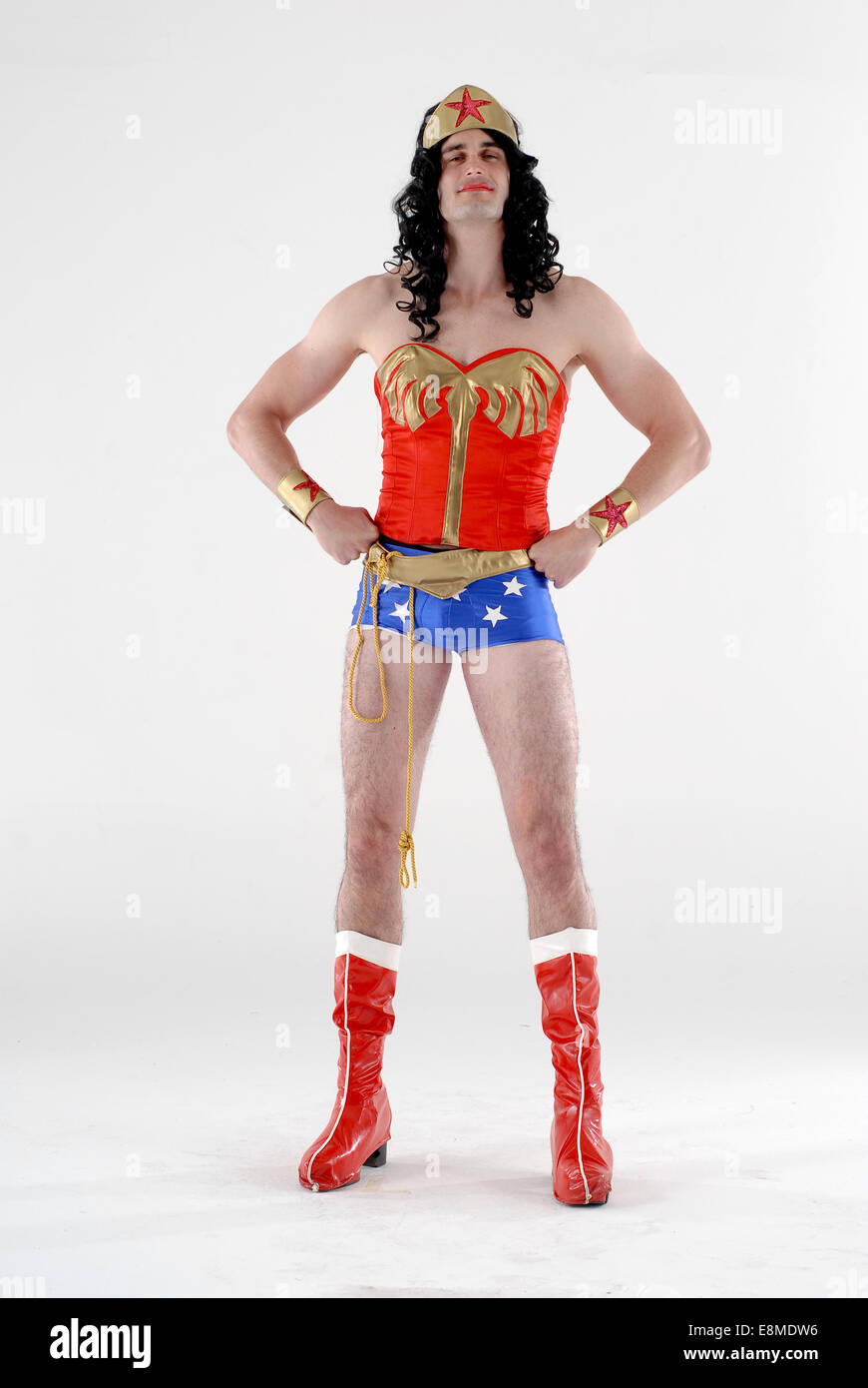 man in fancy dress comedy costume in a DC comics wonder woman super hero outfit, with red boots, hot pants, wig and red top Stock Photo