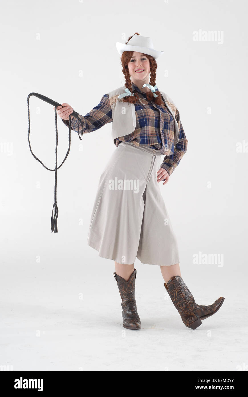 Woman in fancy dress comedy costume in a cow girl outfit with cowboy boots, hat and full on barn dance outfit Stock Photo