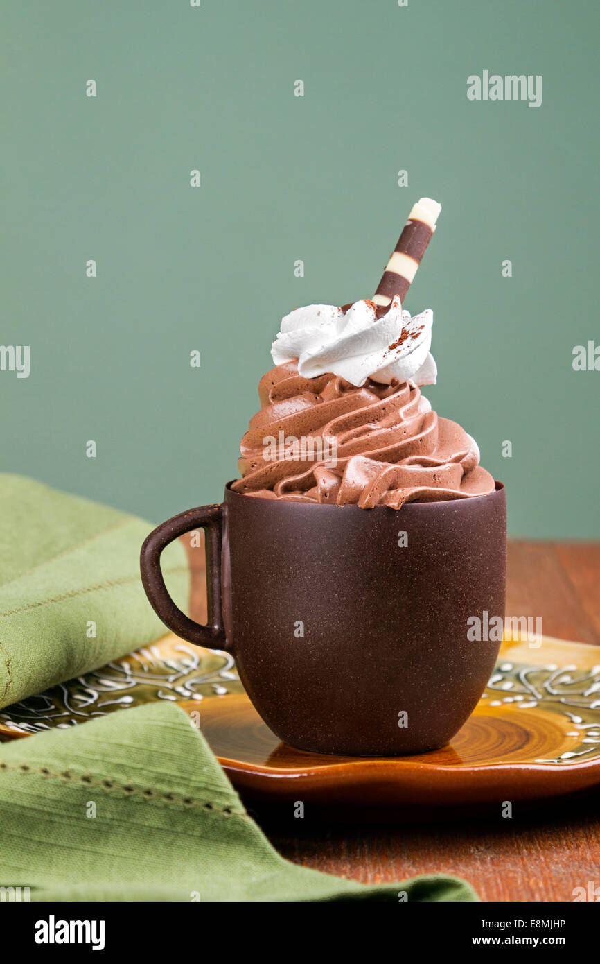 Chocolate cup filled with custard served at a table Stock Photo