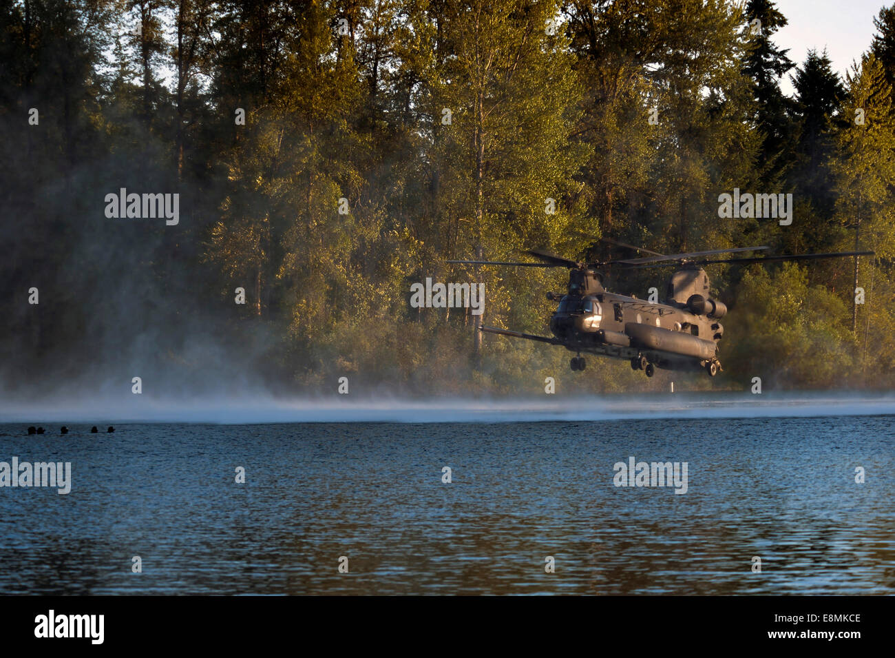 July 14, 2014 - Airmen wait in American Lake for an MH-47 Chinook helicopter to extract them during helocast alternate insertion Stock Photo