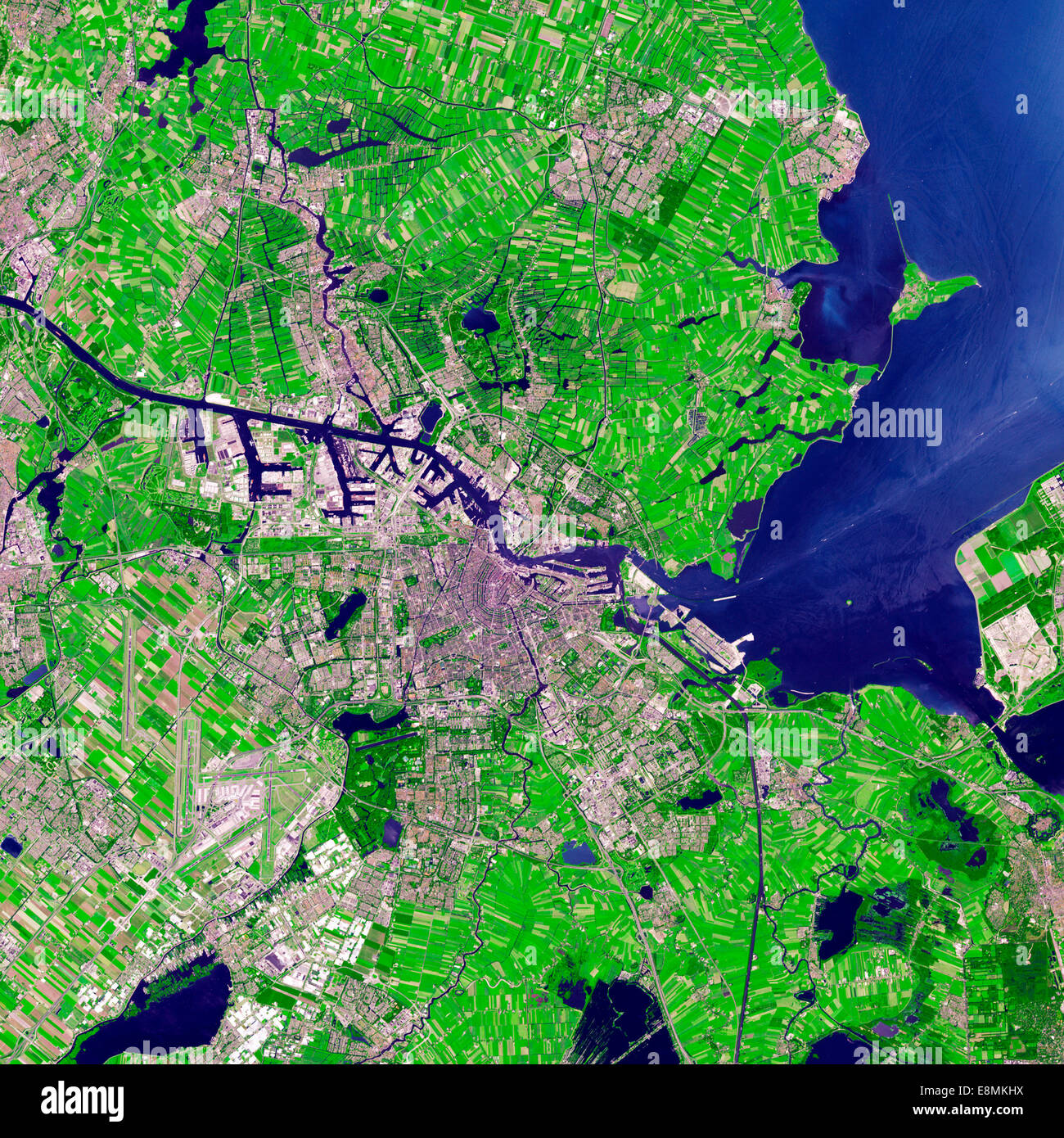 July 24, 2012 - Satellite view of Amsterdam, Netherlands. Urbanized areas appear in shades of gray; vegetation is red; and water Stock Photo