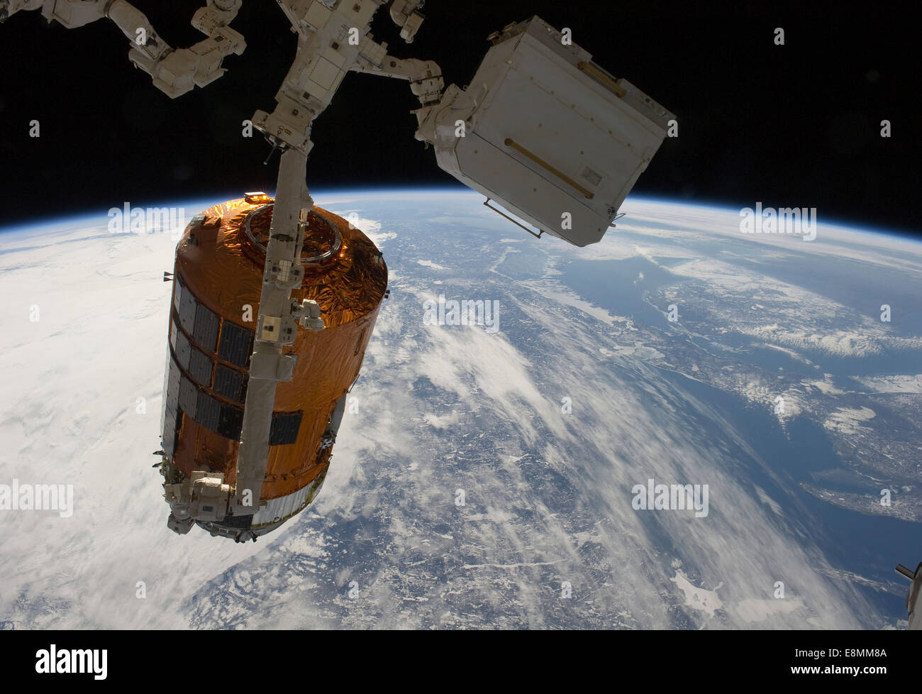 March 28, 2011 - Backdropped by Earth's horizon and the blackness of space, the International Space Station's Canadarm2 unberths Stock Photo