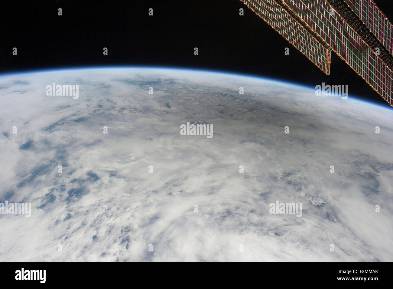 May 20, 2012 - A shadow of the moon from a solar eclipse spreads across cloud cover on Earth. One of the space station's solar a Stock Photo