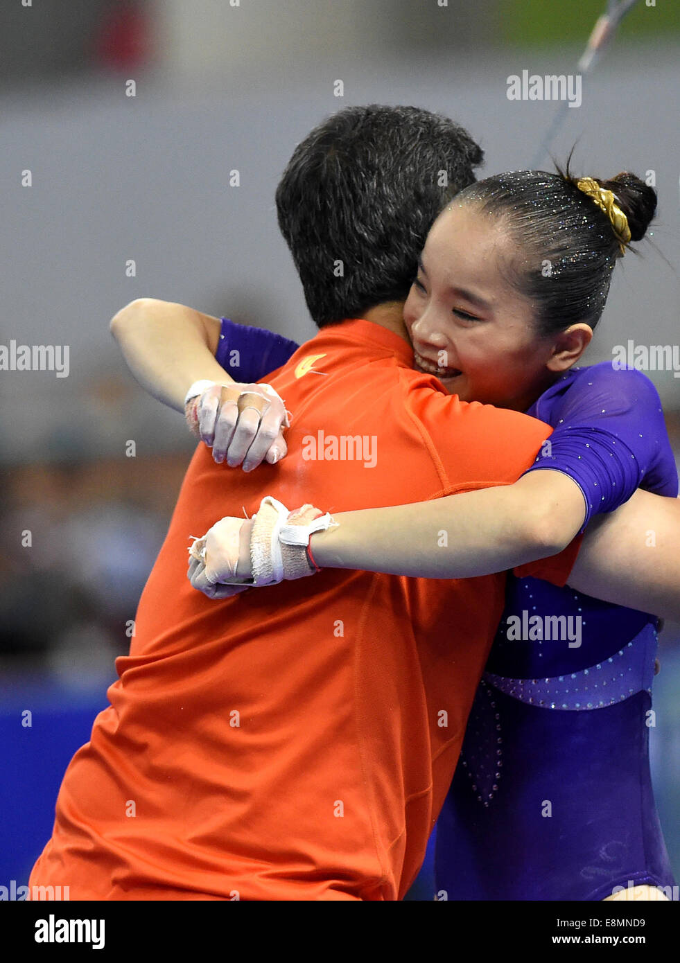 Nanning, China's Guangxi Zhuang Autonomous Region. 11th Oct, 2014. Yao Jinnan (R) of China celebrates with her coach after her performance on the uneven bars during the women's individual apparatus finals of the 45th Gymnastics World Championships in Nanning, capital of south China's Guangxi Zhuang Autonomous Region, Oct. 11, 2014. Yao Jinnan won the gold medal in the women's uneven bars final with 15.633 points. Credit:  Liang Xu/Xinhua/Alamy Live News Stock Photo