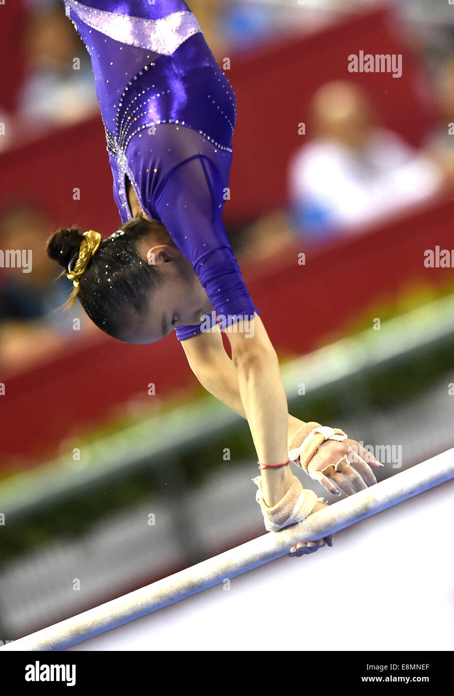 Nanning, China's Guangxi Zhuang Autonomous Region. 11th Oct, 2014. Chinese gymnast Yao Jinnan performs on the uneven bars during the women's individual apparatus finals of the 45th Gymnastics World Championships in Nanning, capital of south China's Guangxi Zhuang Autonomous Region, Oct. 11, 2014. Yao Jinnan won the gold medal in the women's uneven bars final with 15.633 points. Credit:  Xiao Yijiu/Xinhua/Alamy Live News Stock Photo